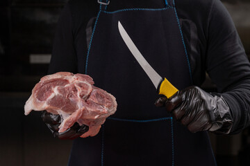 Pieces of raw pork on a red cutting board with a knife