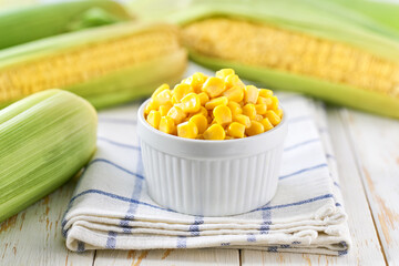 canned food maize in a white ceramic bowl on a white kitchen table, selective focus.