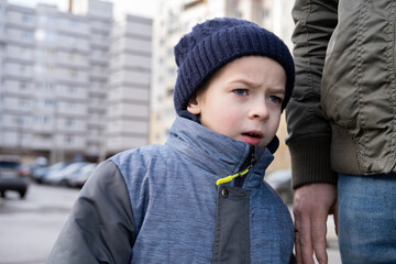 Father and son walking down on sidewalk together. Portrait of a handsome middle-aged man with...