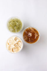 Thai ice tea in plastic cup on white background, top view