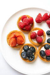 Tartlets with fresh berries on a white background. Selective focus.