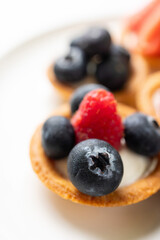 Tartlets with fresh berries on a white background. Selective focus.