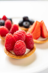 Tartlets with fresh berries on a white background. Selective focus.