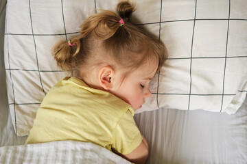 Peaceful adorable baby sleeping on a bed at home. Slumbering little child. Two years old girl...
