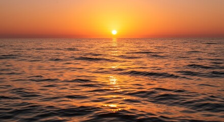Obraz premium Golden sunset reflecting on the rippling ocean surface creating a calming ambiance