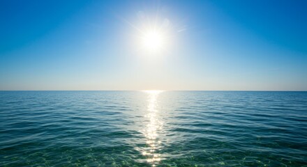 Obraz premium Brilliant sun illuminates tranquil ocean waters under clear, azure sky