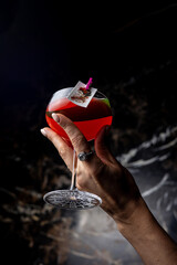 Female hand holding a red cocktail