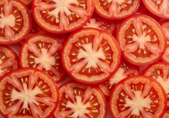 Juicy tomato slices arranged in a close-up pattern showing vibrant texture and seeds