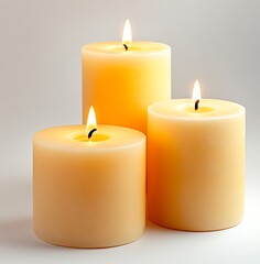 Three Cream-Colored Pillar Candles Burning on White Background