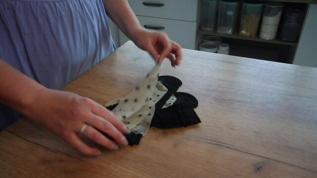 Woman arranging nylon socks with different prints on a table while reviewing the purchase, sock set.