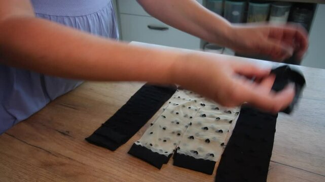 Woman arranging nylon socks with different prints on a table while reviewing the purchase, sock set