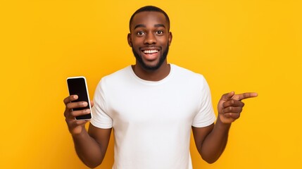 Young happy African American hipster man with smartphone energetically advertising on vibrant yellow background