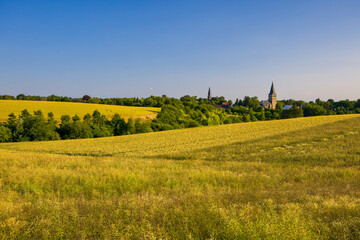 the two churches called Wiesnasen of Ratingen Homberg at summer	evenig sun with blue sky and rye...