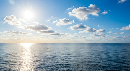 Obraz premium Serene Ocean Vista with Sunlit Reflection and Fluffy Cloudscape Panorama