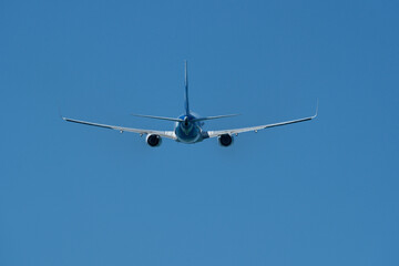 Airplane in the blue sky. An airplane moving away after takeoff