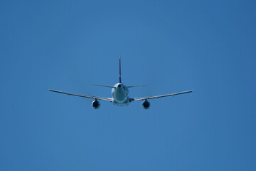 Airplane in the blue sky. An airplane moving away after takeoff