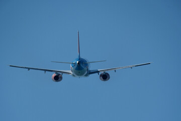 Airplane in the blue sky. An airplane moving away after takeoff