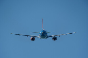 Airplane in the blue sky. An airplane moving away after takeoff