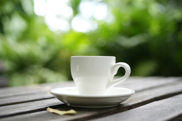 White coffee cup with lush green background