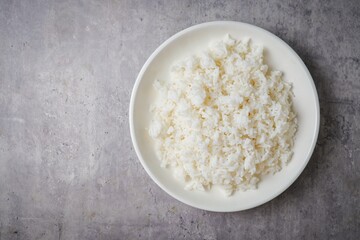 Cooked white rice or steamed rice in a white plate,thai jasmine rice, thai fragrant rice, top view food table