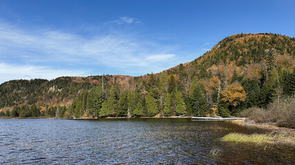 Autumn landscape with lake, forest and mountains in the background. Quebec, Canada.