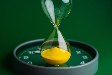 Hourglass stops time of work and life. Process and rules of limited time. Hourglass photo in studio.