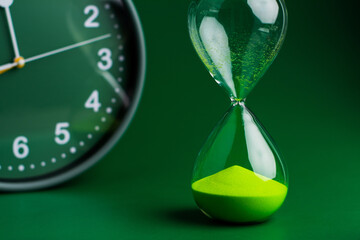 Hourglass stops time of work and life. Process and rules of limited time. Hourglass photo in studio.
