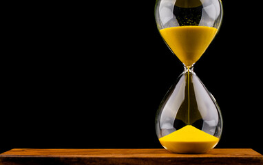 Hourglass stops time of work and life. Process and rules of limited time. Hourglass photo in studio.
