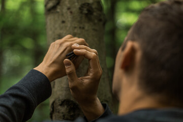 a young man carving on a tree 