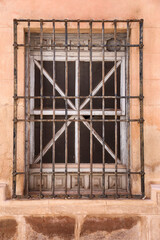 Stone facade with window with wrought iron lattice in Spain