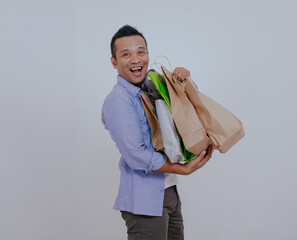 Asian man shopper carrying a lot of shopping bags, isolated on white background.