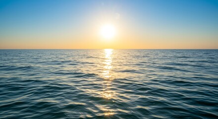 Fototapeta premium Serene ocean view featuring rippled water glistening under a bright sunlit blue sky