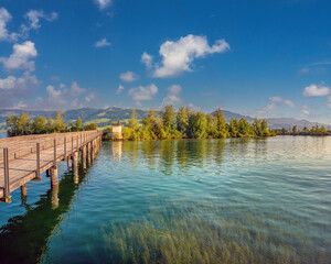 Holzbrücke Rapperswil-Hurden and its  Heilighüsli chapel, Switzerland. Underwater Süsswassertang algae forests can be seen in the clear waters of Lake Zurich