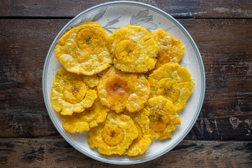 Delicious patacones or tostones on ceramic plate
