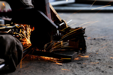 cutting a steel plate with an electric cutting wheel at a factory