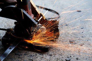cutting a steel plate with an electric cutting wheel at a factory