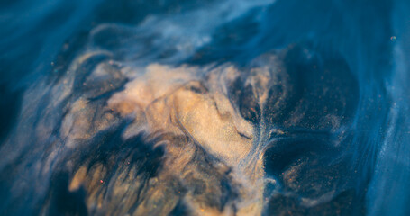 Sparkling flow. Ink mix. Golden black acrylic stream wave blend. Art liquid spilling color wet texture defocused abstract background.