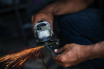 Grinding a steel plate with an electric hand wheel at a factory