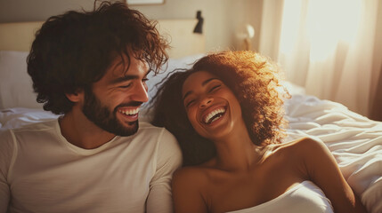 Joyful interracial couple laughing and playing together on bed in cozy morning light, holding hands and sharing affection multicultural love, diverse couple, happy romance, mixed-r