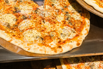 Close-up of freshly baked pizza with melted cheese and herbs. Italian street food, fast casual...
