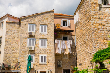 Sunlit stone houses with drying laundry in a Mediterranean old town. Daily life, authentic...
