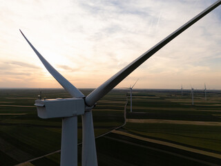 Aerial view of wind turbine on an agricultural filed at sunset. Close up of blades