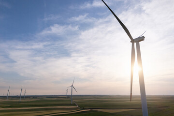 Aerial view of wind turbine on an agricultural filed at sunset. Close up of blades