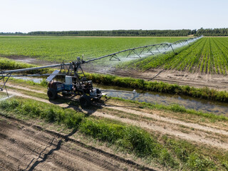 Autonomous machine is moving watering pivot along irrigation canal