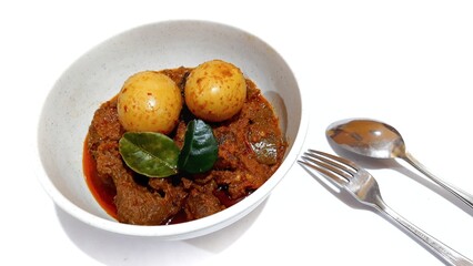 Beef Toppa Lada with eggs served in a white bowl. Popular Indonesian food from Makassar, South Sulawesi