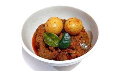 Beef Toppa Lada with eggs served in a white bowl. Popular Indonesian food from Makassar, South Sulawesi