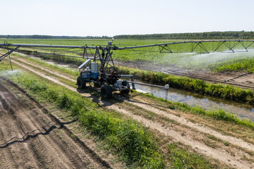 Autonomous machine is moving watering pivot along irrigation canal