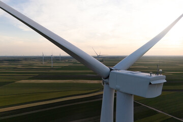 Aerial view of wind turbine on an agricultural filed at sunset. Close up of blades