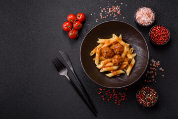 Penne pasta with meatballs in tomato sauce with salt and spices. Italian food penne pasta