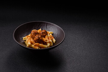 Penne pasta with meatballs in tomato sauce with salt and spices. Italian food penne pasta